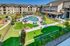 Luxurious apartment complex boasting a sparkling pool, spacious sun deck, and beautifully landscaped gardens for ultimate relaxation.