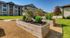 Charming apartment complex with lush garden planters and serene landscaping, offering a peaceful community vibe.