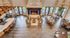 Luxurious lounge area with a grand fireplace, elegant chandeliers, and spacious dining and seating arrangements in a modern open-concept design.