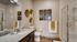 Modern bathroom with elegant granite countertops, sleek fixtures, and stylish wall art, creating a luxurious and welcoming atmosphere.