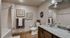 Elegant bathroom featuring granite countertops, decorative wall art, and a modern shower-tub combo with stylish fixtures.