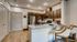 Modern apartment kitchen with granite countertops, stylish bar seating, and stainless steel appliances.