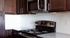 Modern kitchen showcasing sleek granite countertops, dark wood cabinets, and stainless steel appliances.