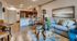 Modern open-concept living space featuring a cozy sofa, elegant wood table, and a stylish kitchen with bar seating.