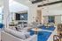 Luxurious open-concept lounge with modern gray sofas, vibrant blue accents, and stylish lighting features, creating an inviting social space.