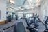 Modern fitness center with state-of-the-art gym equipment, bright lighting, and spacious layout for optimal workout experience.