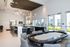 Elegant communal lounge with chic bar area, plush seating, and modern lighting, ideal for social gatherings.