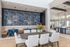 Elegant and spacious communal dining area with vibrant floral wall art and modern decor, perfect for social gatherings.