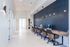 Modern coworking space with sleek computers, elegant pendant lighting, and comfortable seating, perfect for productivity.