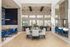 Sophisticated dining area featuring vibrant blue chairs and elegant decor under sleek modern lighting, set within a spacious and airy room with large windows.
