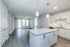 Modern open-concept kitchen and living area with sleek grey flooring and stylish pendant lighting.