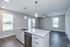 Modern open-plan apartment with stylish granite kitchen island, sleek cabinetry, and vibrant natural light from floor-to-ceiling windows.