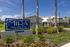 MIRA Active Adult Living community entrance showcasing vibrant landscaping and modern architecture under a clear blue sky.