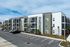 Modern apartment complex with sleek design, spacious balconies, and ample parking in a scenic setting.