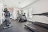 Modern fitness center equipped with top-of-the-line cardio machines and strength training equipment in a bright, spacious setting.