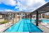 A photo of a lap pool with a deck and seating