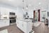 Bright and inviting open-concept layout featuring elegant hardwood floors, a modern kitchen with stainless steel appliances and sleek cabinets, perfect for contemporary living.