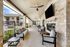 Inviting covered patio with modern seating, overlooking a sparkling pool and charming apartment complex.