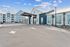 Modern apartment complex with stylish architecture, featuring sleek buildings and lush landscaping under a bright blue sky.