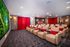 a room with large cozy chairds and a large screen to gather