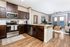 an apartment with stainless steel appliances, faux wood cabinets and vinyl wood flooring