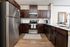 an apartment with stainless steel appliances, faux wood cabinets and vinyl wood flooring
