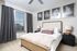 A spacious bedroom with a queen size bed and plush white carpeting