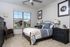 A spacious bedroom with a queen size bed and plush white carpeting