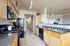 Modern kitchen with sleek black appliances, light wood cabinets, and granite countertops.
