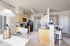 Stylish open kitchen space with modern appliances and dining area illuminated by natural light.