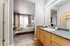 Inviting bedroom with large window, cozy bed, and an adjacent modern bathroom.