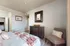 Cozy bedroom with floral bedding, wooden dresser, and stylish decor elements.