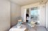 Inviting balcony with two cushioned chairs and a round table adorned with a decorative plant.