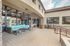 Inviting outdoor patio with stylish turquoise furniture, large windows, and elegant stone accents.