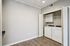 Modern laundry room with sleek washer and dryer, elegant white cabinetry, and stylish wood flooring.
