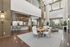 Elegant and modern open-concept Leasing Center, featuring a stylish seating area, round dining table, and chic bar counter under a unique architectural design.