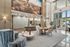 Elegant lobby with modern furnishings, vibrant artwork, and floor-to-ceiling windows, offering a welcoming atmosphere.