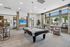 Stunning recreation room featuring a stylish pool table, cozy seating, and large windows with scenic views.