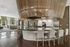 Luxurious space featuring a modern kitchen with a sleek countertop, stylish bar seating, and gourmet coffee machine.