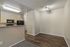 Bright, modern kitchen and dining area featuring stylish countertops, sleek black appliances, and warm wooden flooring.