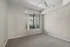 Bright, spacious room with soft carpet, large window with a hillside view, and a ceiling fan for comfort and style.