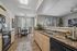 Chic modern kitchen leading to an inviting dining area with large windows offering natural light.