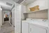 Bright and efficient laundry area featuring modern washer and dryer with built-in cabinetry and natural lighting.
