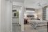 Inviting bedroom with plush bedding, modern decor, and a spacious walk-in closet in a cozy setting.