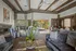 Elegant living room with modern decor, featuring plush blue and gray sofas, artistic accents, and large windows inviting natural light.