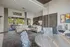 Inviting open-concept living and dining area with elegant decor, stylish furniture, and a view of a scenic outdoor patio.