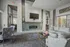 Elegant modern living room with a stylish fireplace, chic furniture, and large windows inviting natural light.