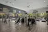 Spacious and modern fitness center with state-of-the-art equipment, bright natural lighting, and sleek wooden flooring, ideal for a dynamic workout.
