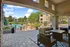 Elegant apartment patio with comfortable seating overlooking a sparkling pool, surrounded by lush greenery and stylish architecture.