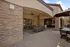 Elegant outdoor patio area featuring modern seating, stylish stone walls, and a ceiling fan, perfect for entertaining.